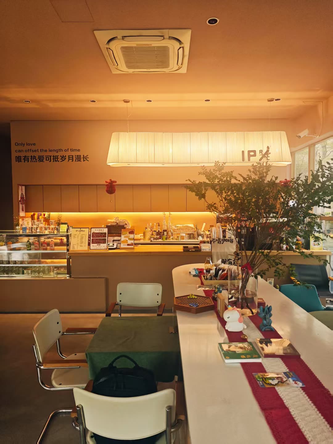 咖啡馆内景：吧台区暖橙灯光与桌椅
